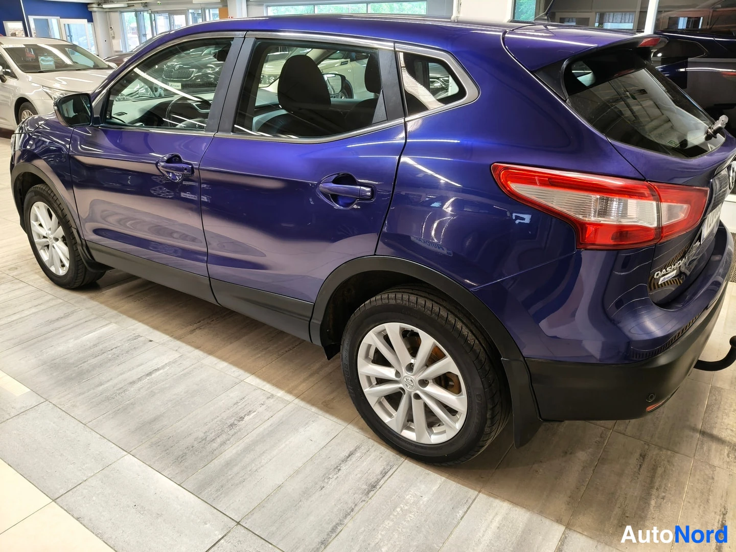 Takaviisto: Rear three-quarter view of the purple car highlighting the rear door handles, alloy wheel rim design, and 'QASHQAI' lettering.