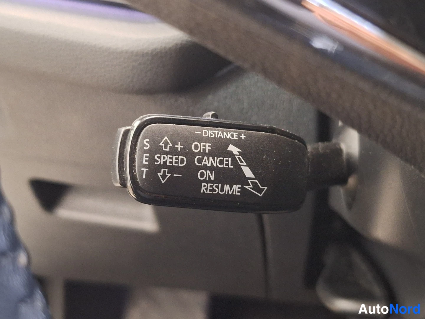 Muu: Ohjaustoston cruise control -kytkin, jossa merkit DISTANCE, OFF, CANCEL, ON, RESUME ja SPEED.