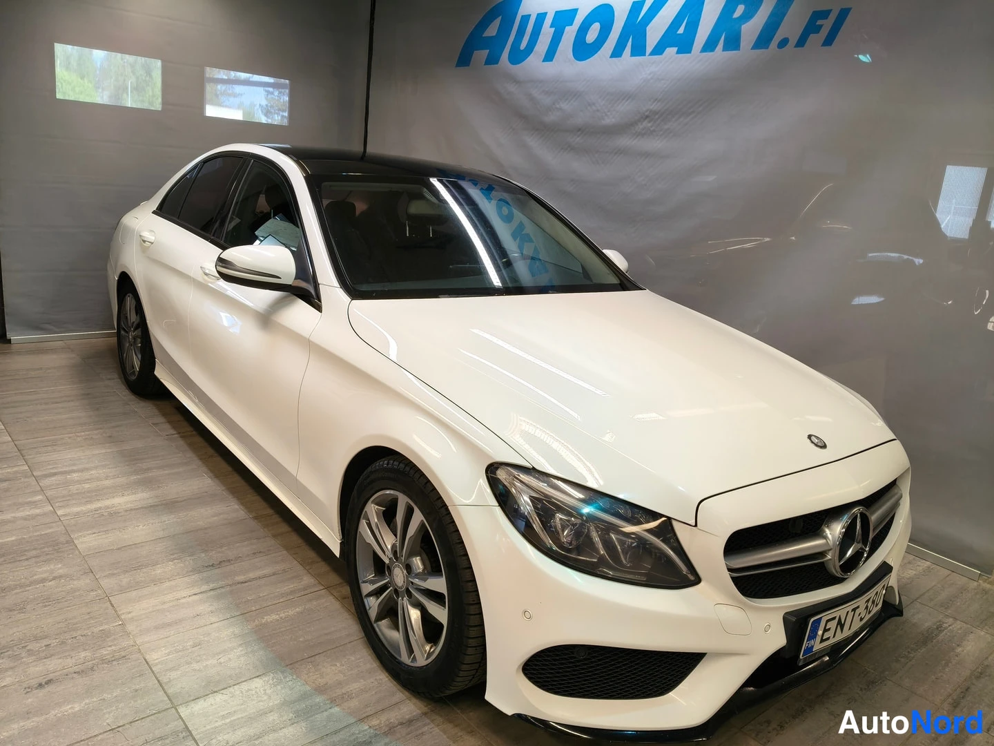 Etuviisto, nokka oikealle: Valkoinen Mercedes-Benz C-sarjan sedan kuvattuna etukolmesta, keula oikealla, rekisterikilpi.