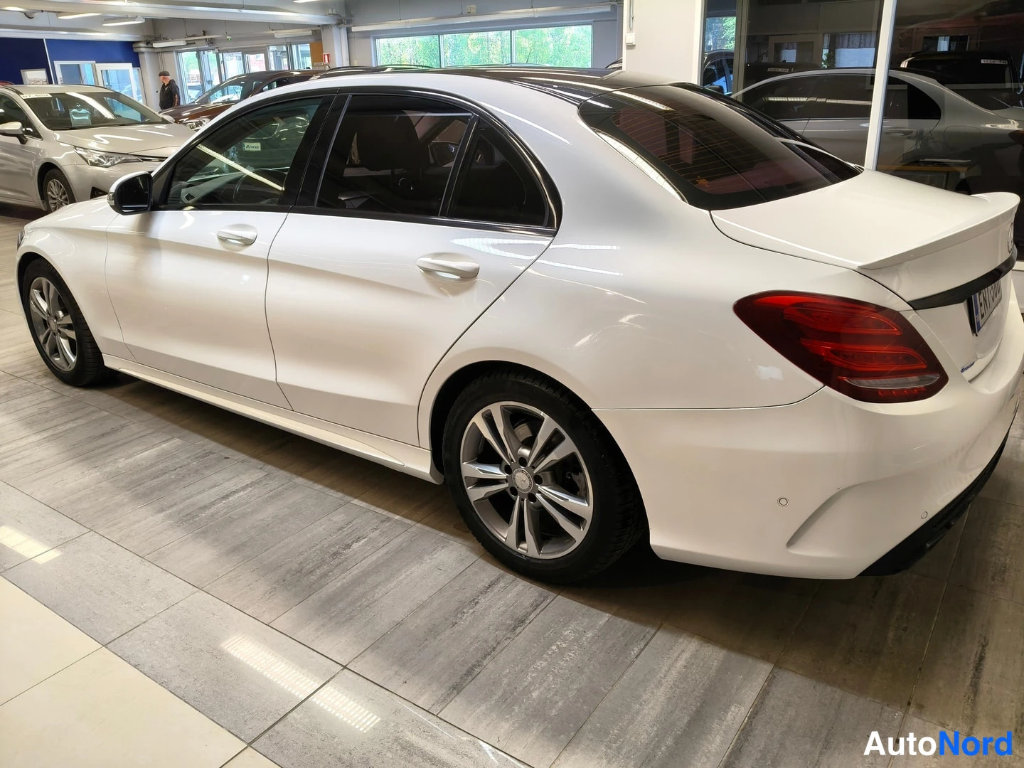 Takaviisto: Valkoisen Mercedes-Benz C-sarjan sedanin takakolmasosanäkymä, vasen kylki ja takavalo näkyvissä.