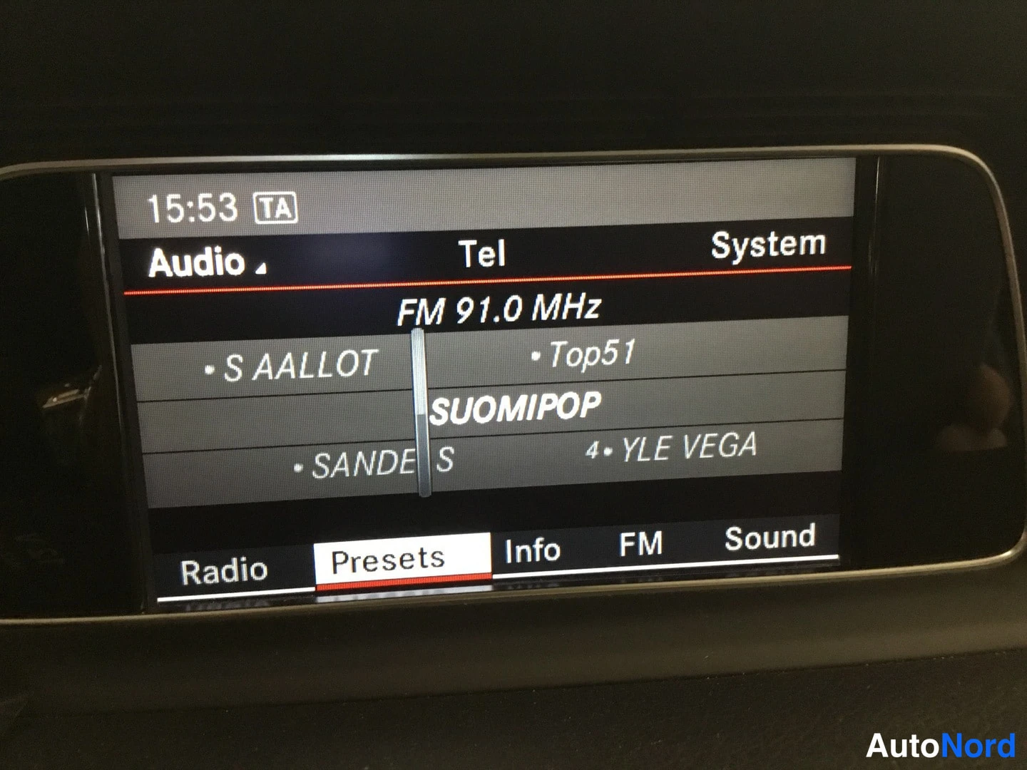 Muu: Auton radion näyttö: Audio-valikko, FM 91,0 MHz ja tallennetut kanavat kuten SUOMIPOP ja YLE VEGA, kello 15:53.