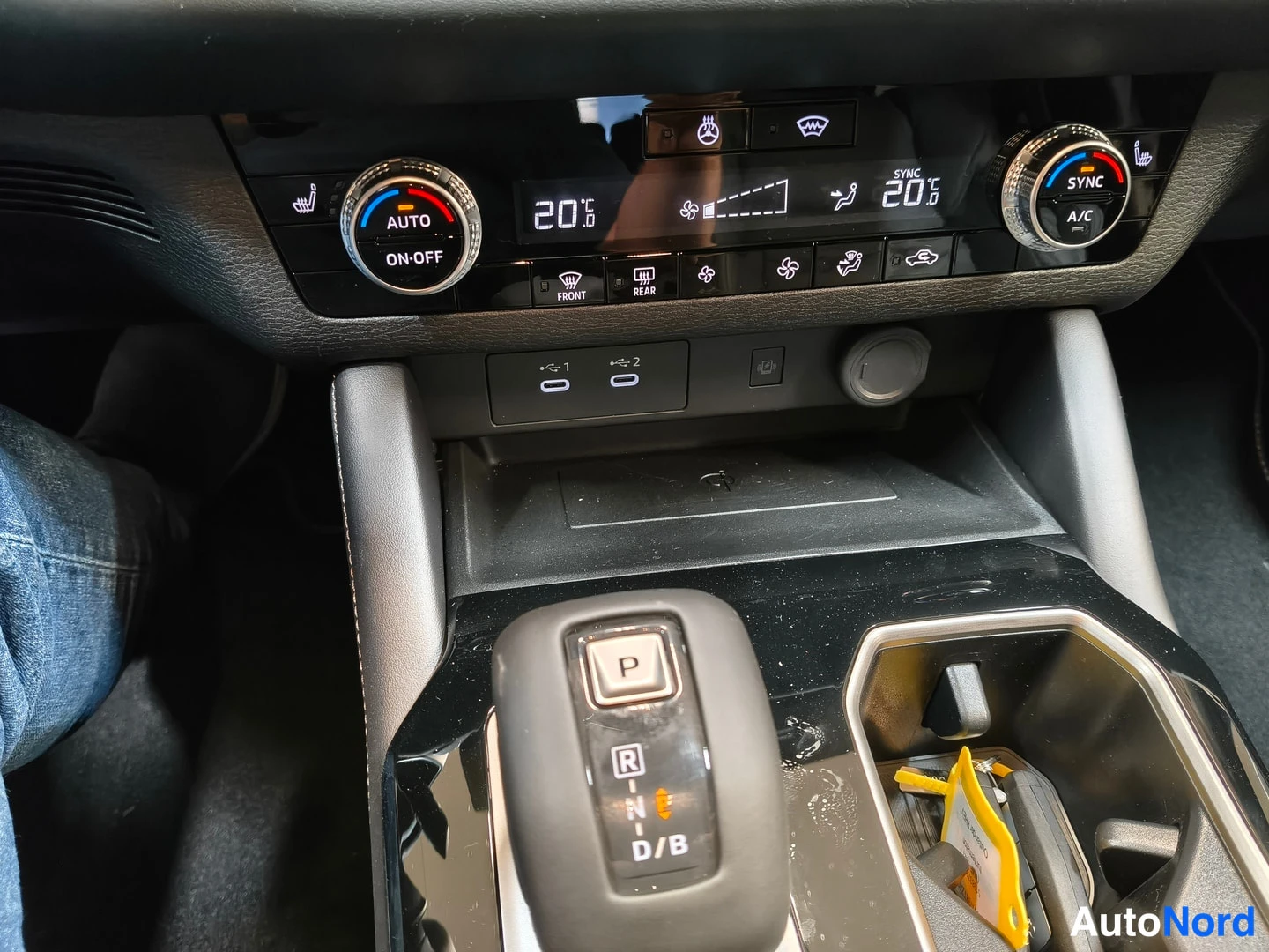 Yksityiskohta: Kojelaudan osa: automaattinen kaksivyöhykkeinen ilmastointi (20 °C, SYNC, A/C), USB-portit ja P/R/N/D/B -vaihteenvalitsin.