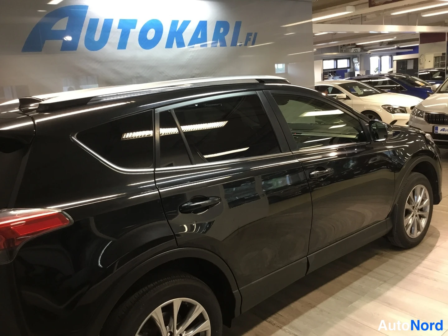 Sivulta: Mustan Toyota RAV4:n oikea kylki autonhallissa.