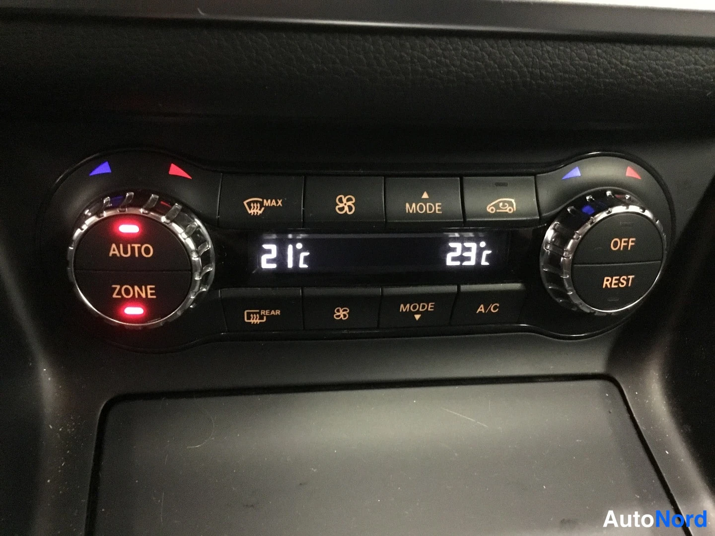 Muu: Mercedesin ilmastointipaneeli; näyttö näyttää 21 °C ja 23 °C, nappeineen AUTO, ZONE, MODE, A/C, REAR ja OFF/REST.