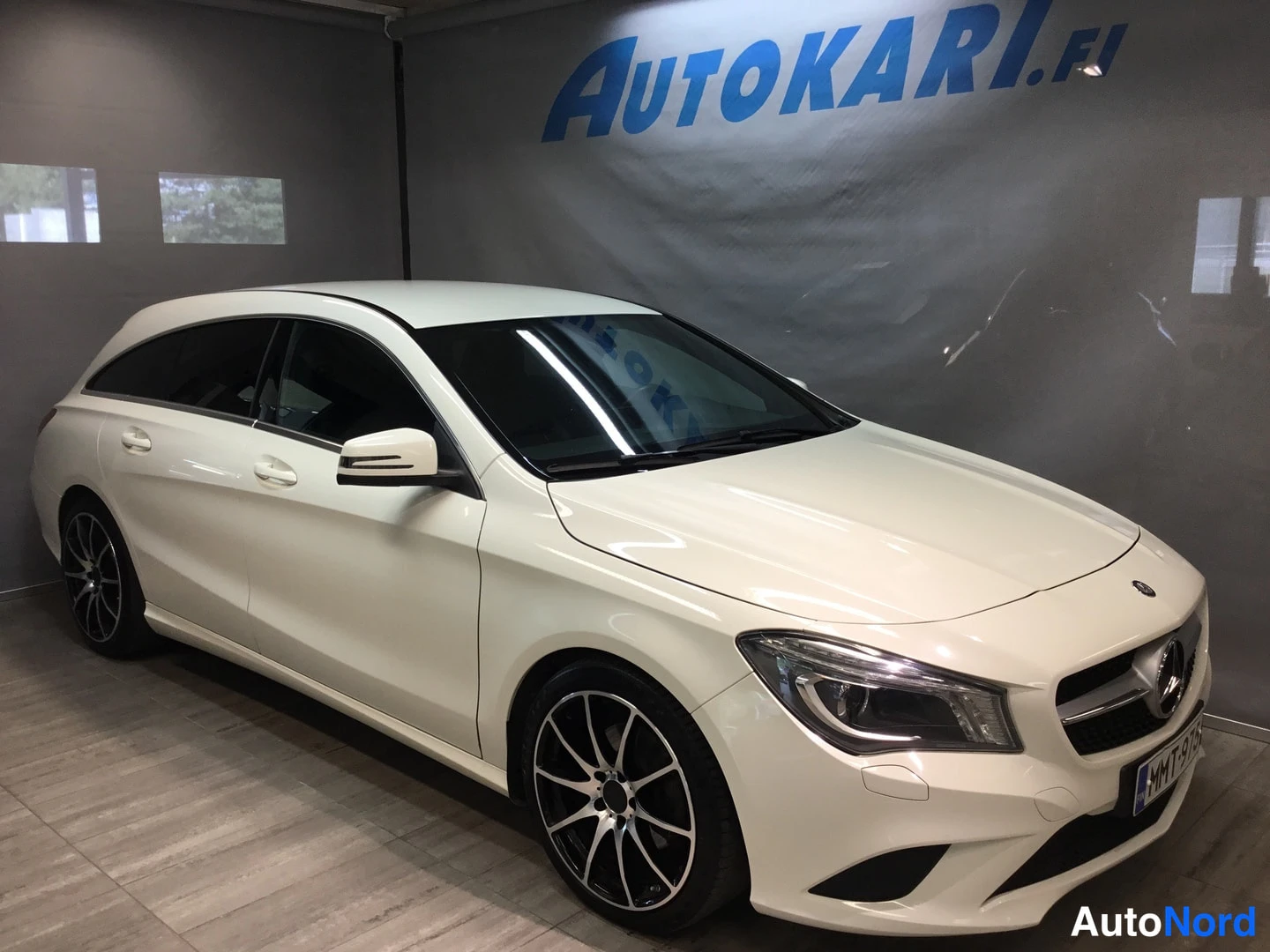 Etuviisto, nokka oikealle: Valkoinen Mercedes-Benz CLA Shooting Brake etukulmasta oikealta, mustat kevytmetallivanteet.