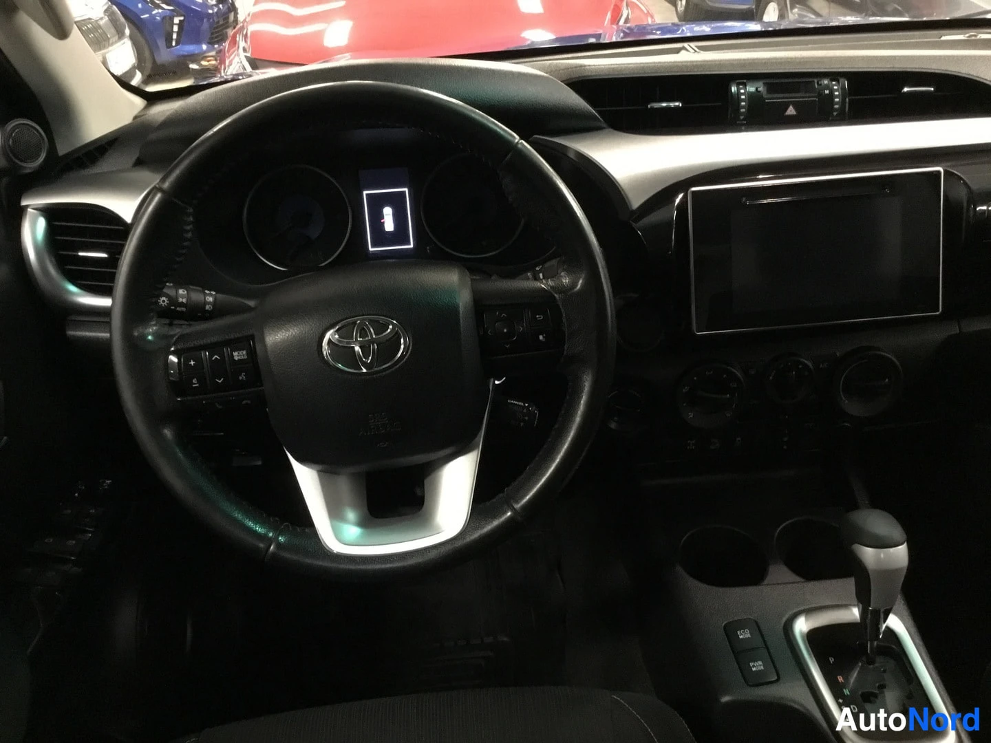 Edestä: Toyota-merkillinen ratkaisu, digitaalinen kojelauta, suurta kosketusnäyttöä ja automaattivalitsin.