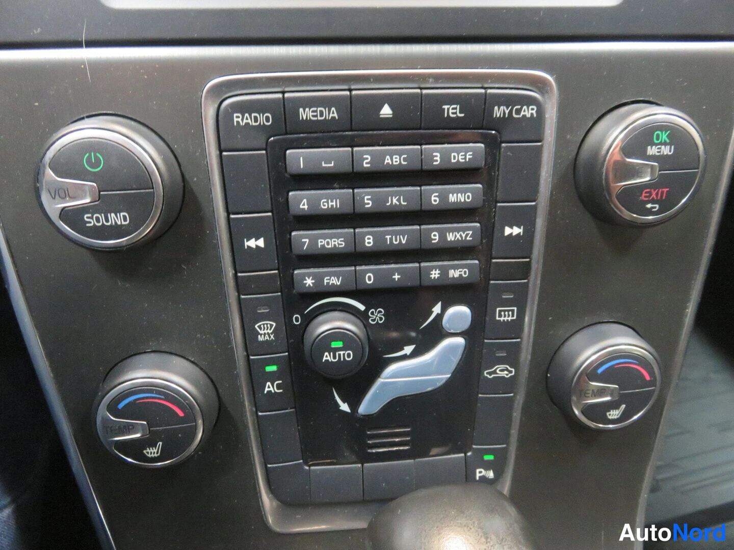 Yksityiskohta: Keskihallinnon paneeli lähikuva: RADIO/MEDIA/TEL/MY CAR -napit, numeronäppäimistö, VOL/SOUND- ja TEMP/OK MENU -renkaat, AUTOn ja AC-napit.