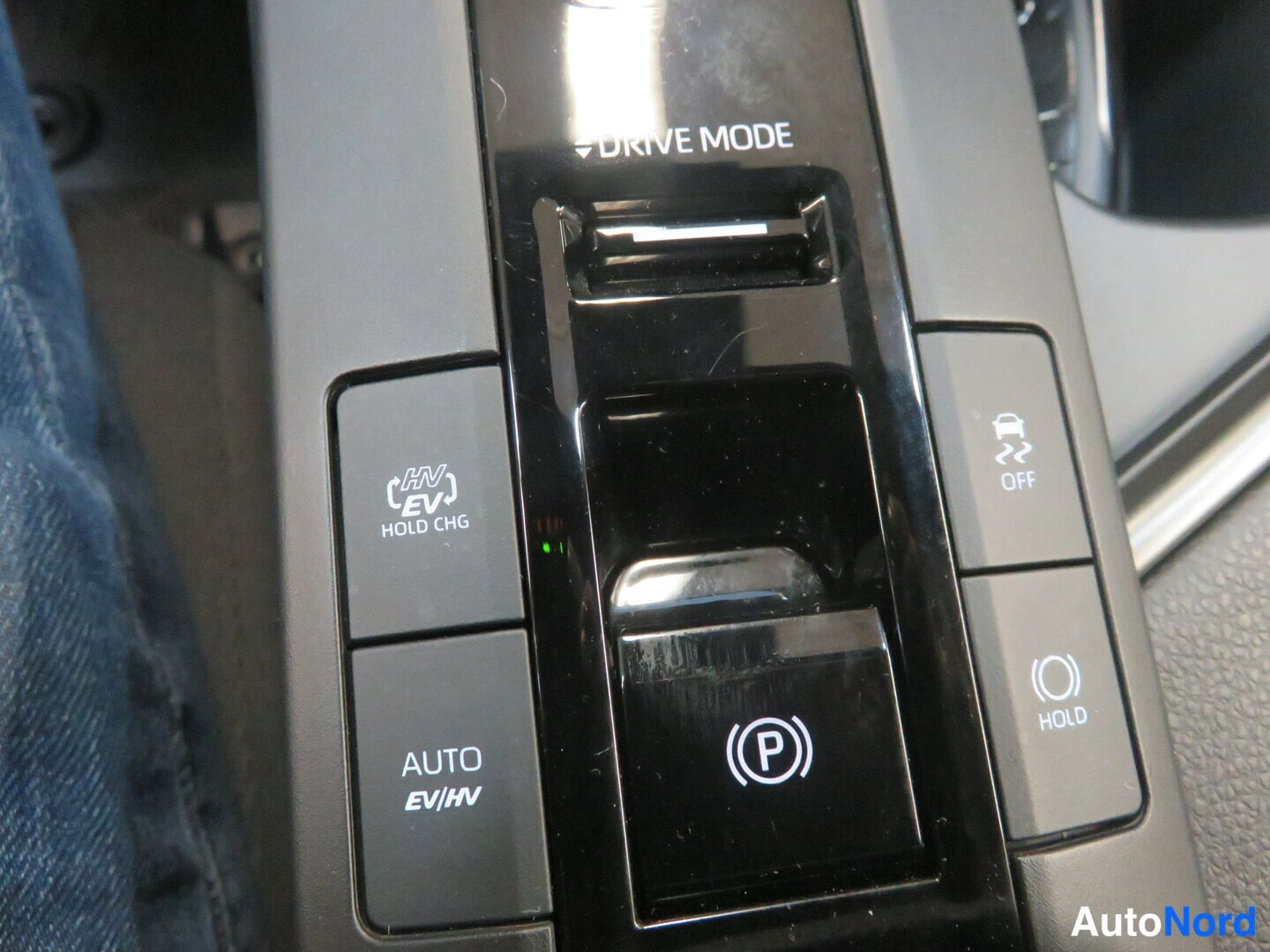 Muu: Autoan keskikonsolin painikkeet: DRIVE MODE, HV/EV HOLD CHG, AUTO EV/HV, hätäjarrunappi (P), liukastus_esto OFF ja HOLD-nappi.