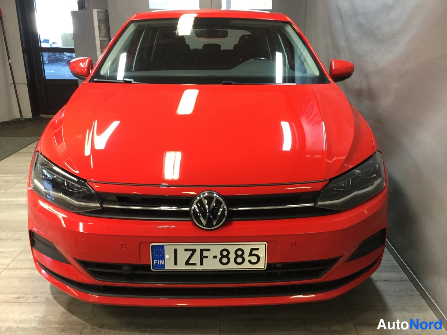 Edestä: Punainen Volkswagen Polo edestäpäin, rekisteritunnus.