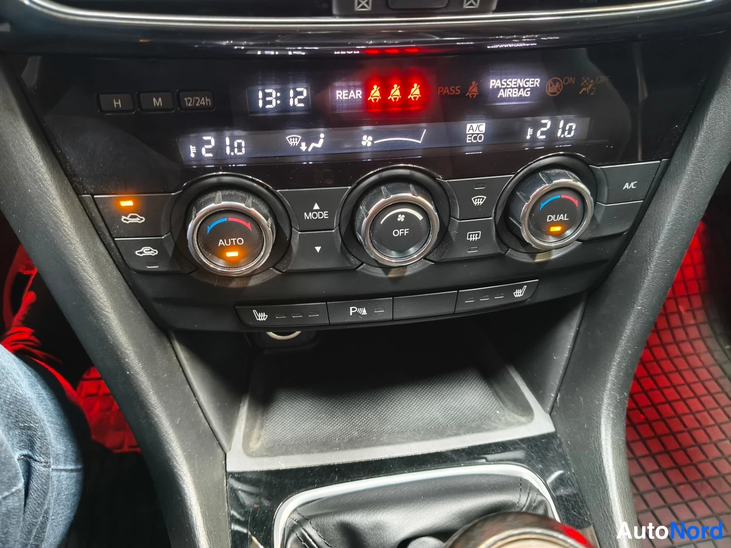 Edestä: Lähikuva kojelaudan ilmastointipaneeleista, joissa näkyy DUAL, AUTO ja A/C-ECO-merkit.