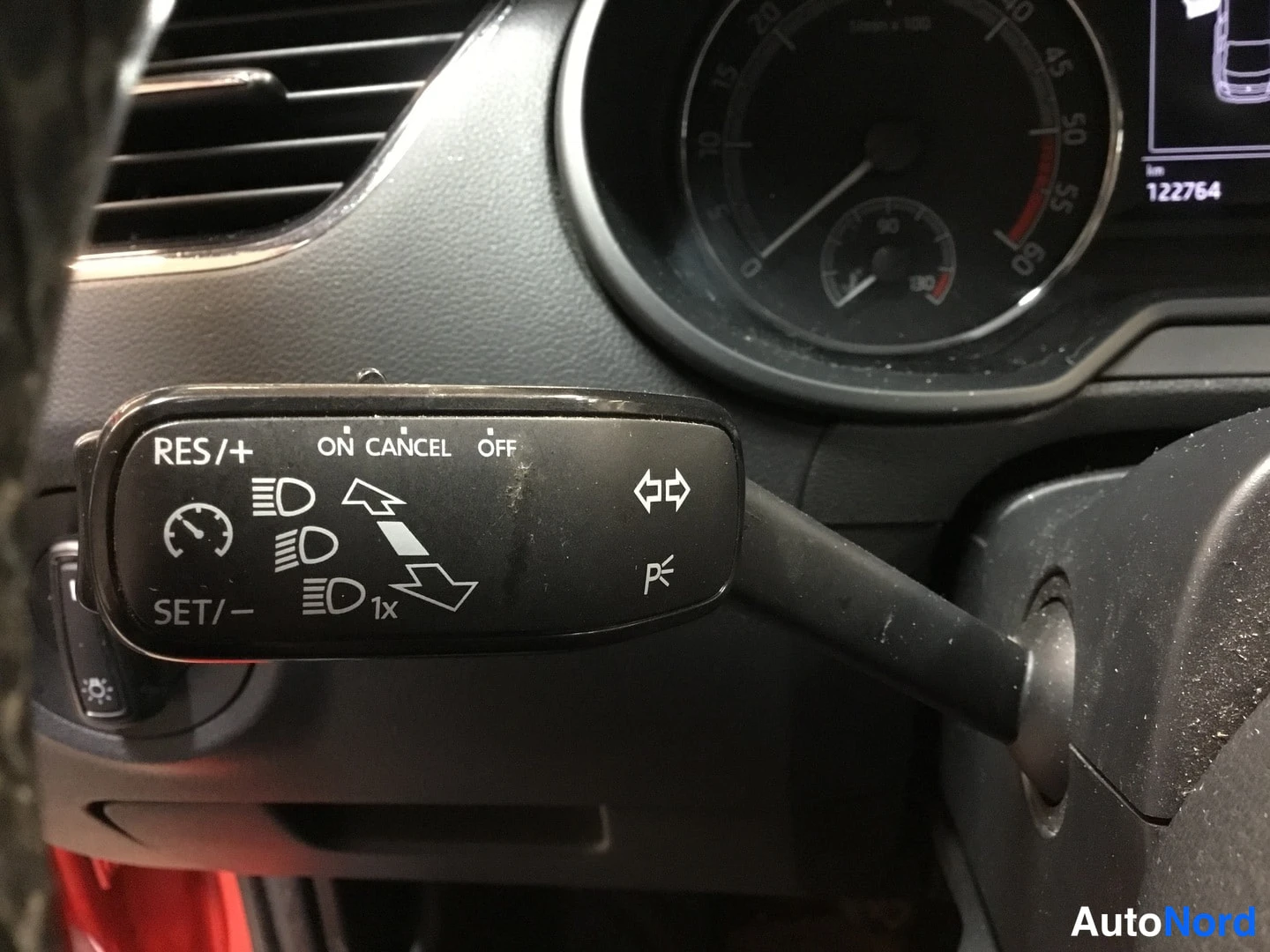 Muu: Vaihtokytkimien ja kojelaudan kuva: mittariston näytössä lukema 122764 km.