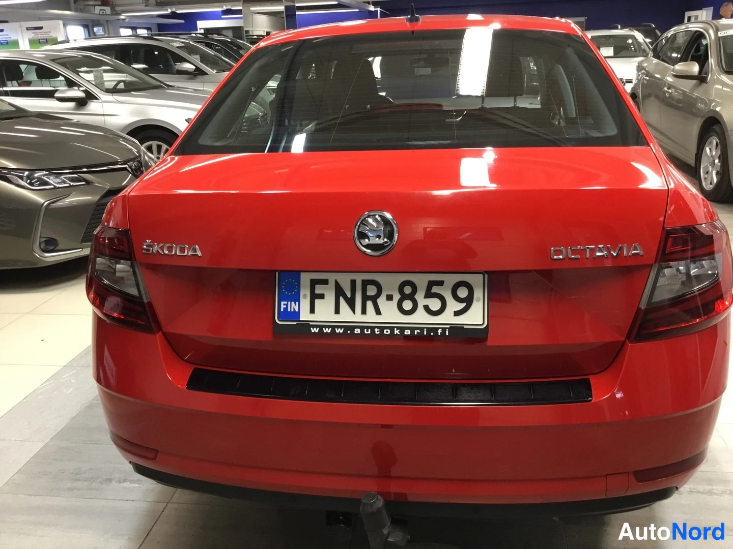 Takaa: Skoda Octavian takaosa suoraan takaa: punainen kori, ŠKODA- ja OCTAVIA-merkit, rekisterikilpi ja vetokoulu telineen alla.