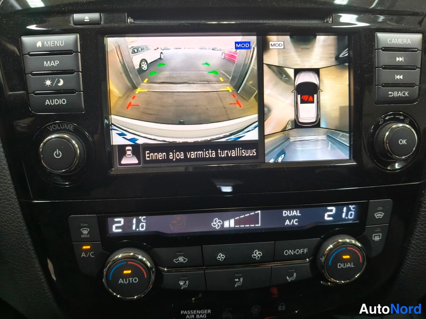 Edestä: Infotainment-näyttö näyttää 360-kaameratekniikan ympärystäkuvan ja teksti 'Ennen ajoa varmista turvallisuus', alla kaksivyöhykeilmastointi 21 astetta.
