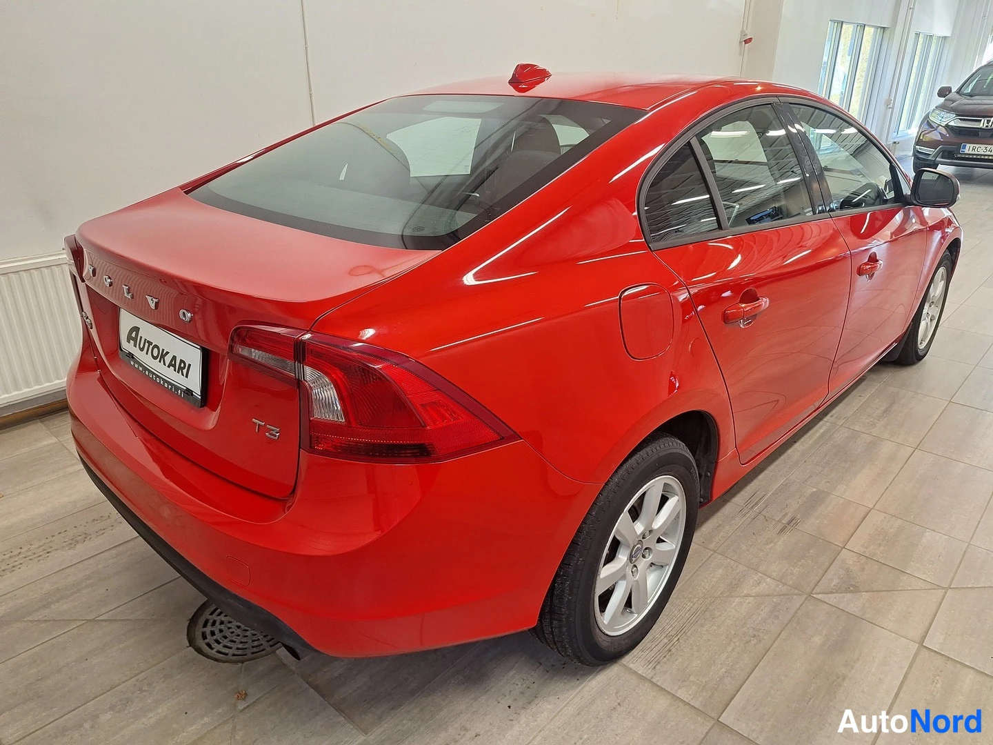 Takaviisto: Punaisen Volvo S60 -sedanin takakolmasosan näkymä sisätiloissa