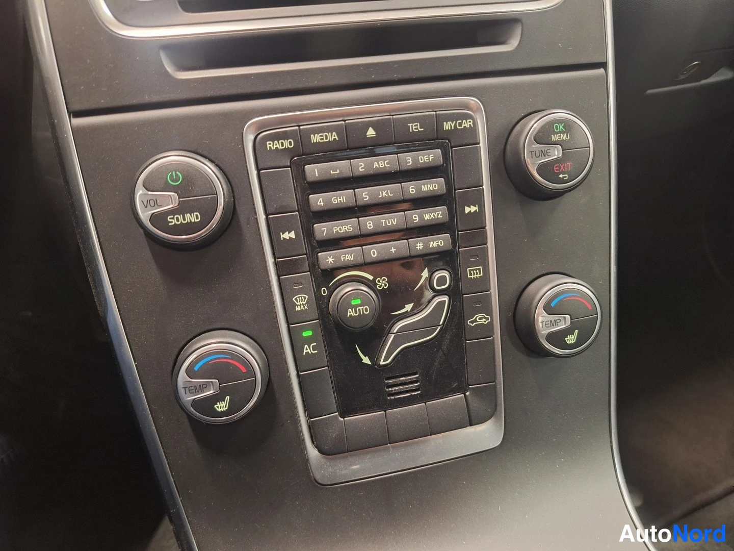 Muu: Keskiöstä näkyy automaatti-ilmastoinnin säätimet (AC, AUTO, TEMP), radio ja nappinäppäimistö.