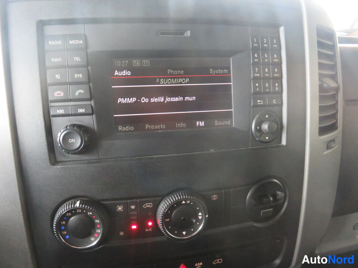 Muu: Mercedes-Benz Sprinterin kojelaudan keskusyksikkö: radio-navigointilaite näyttää radiotoistoa (FM, kanava 'SUOMIPOP', kappale 'PMMP - Oo siellä jossain mun'), y