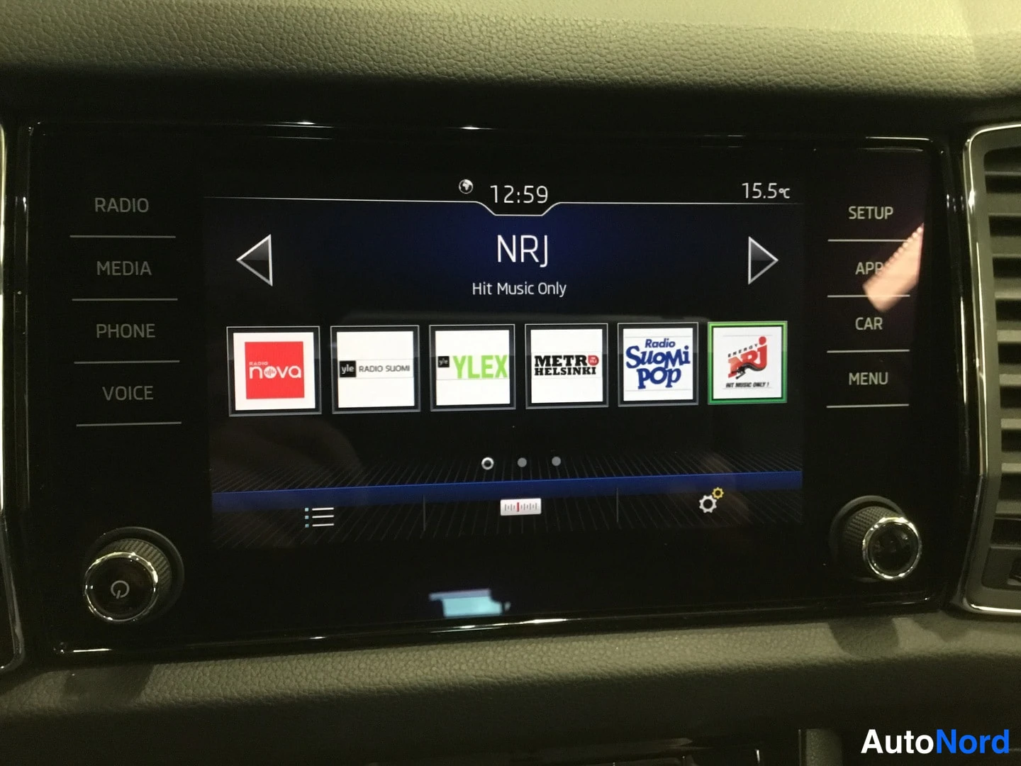 Muu: Kosketusnäytön radiovalikko: toista kanavaa NRJ (Hit Music Only) näkyy kellonaika 12:59, lämpötila 15,5 °C ja kanavapainikkeet Nova, YLE Radio Suomi, YLEX, Metr