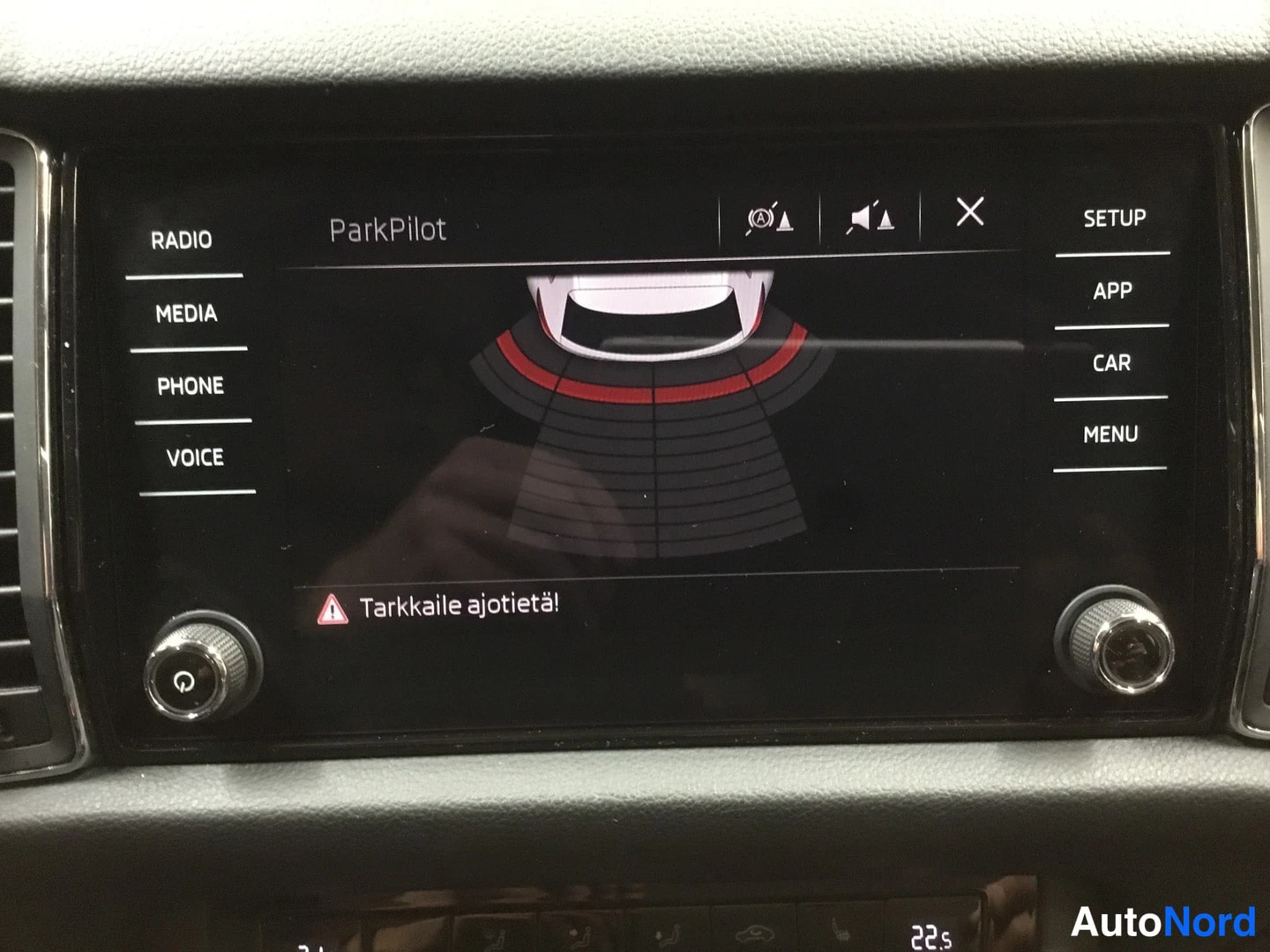 Muu: Kojeiston infotainment-näyttö, jossa näkyy ParkPilot-pysäköintitunnistimen grafiikka ja varoitus 'Tarkkaile ajotietä!'.