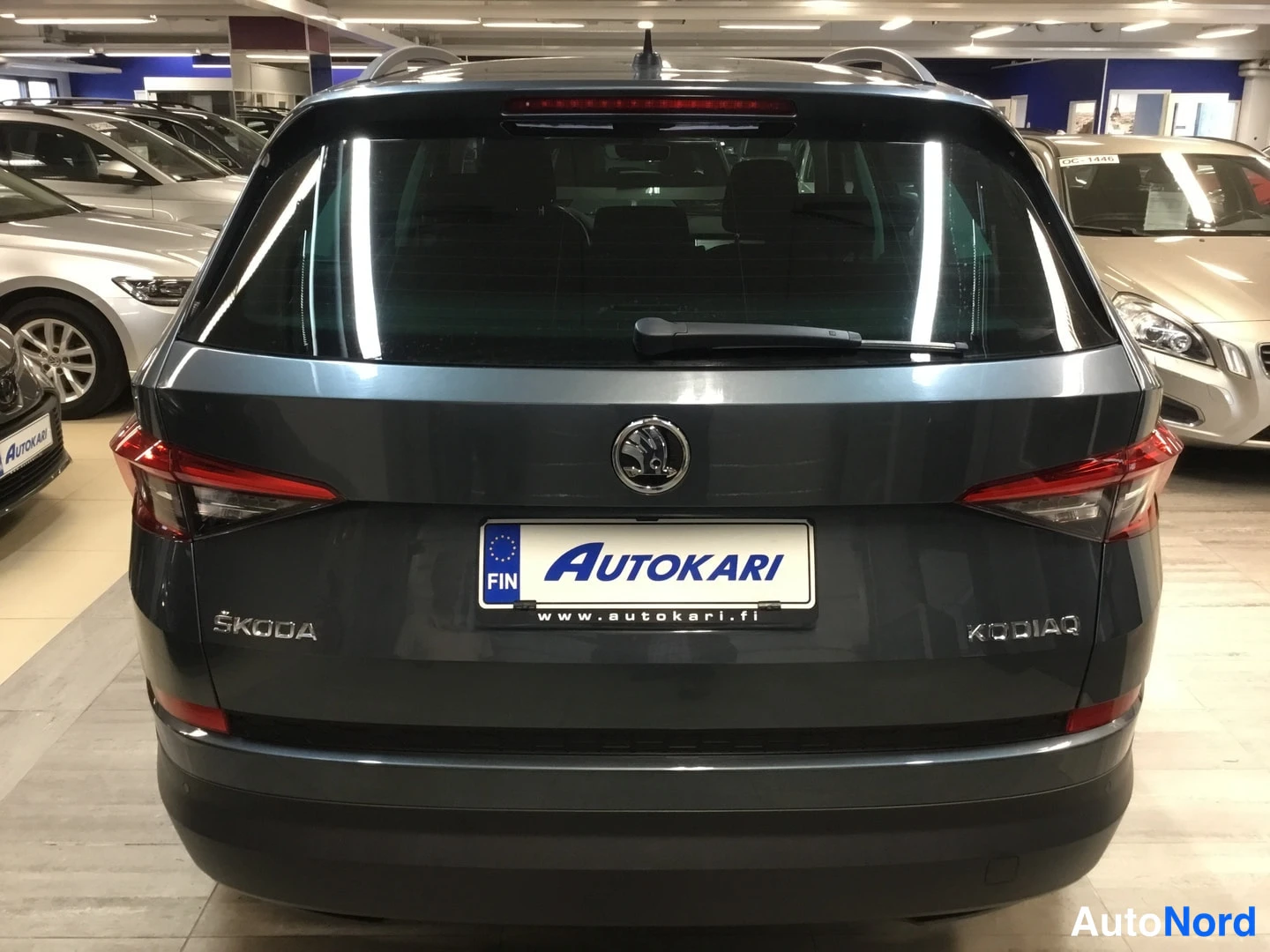 Takaa: Harmaanvärinen Škoda Kodiaq takanäkymässä myymälässä, takavalot ja Kodiaq-merkintä näkyvissä.
