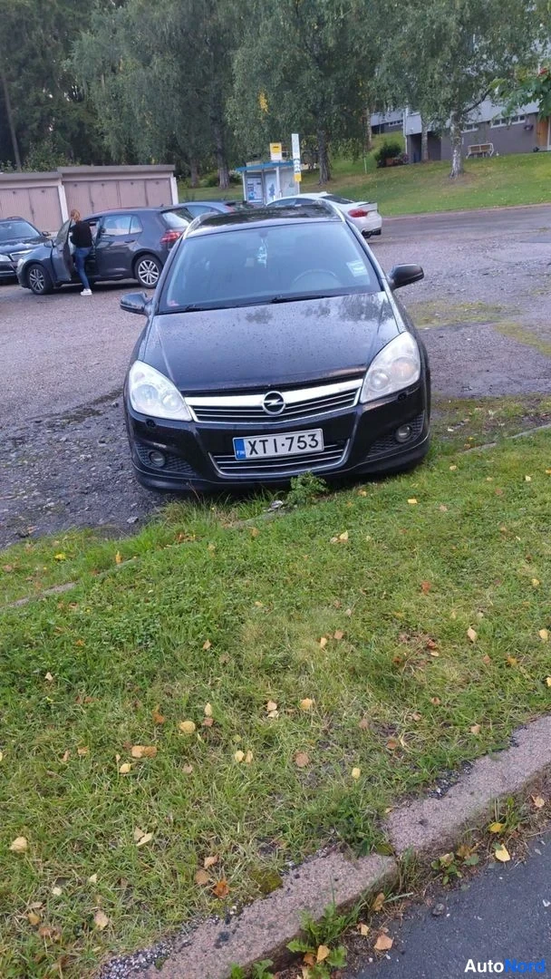 Edestä: Mustan henkilöauton etupää, rekisterikilpi XT I-753
