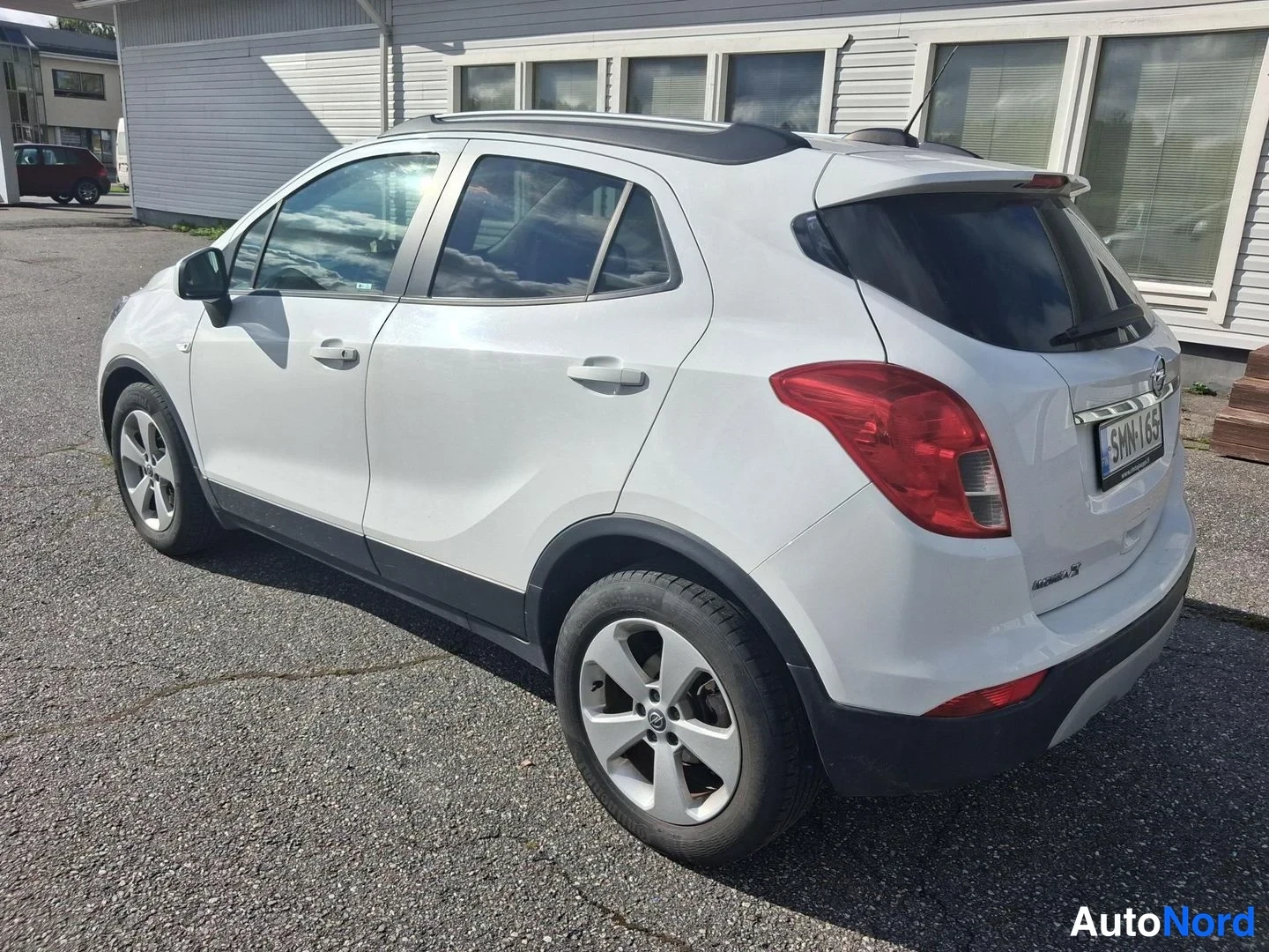 Takaviisto: Valkoisen Opel Mokka X:n takasivaprofiili: katonrakojen, ovenkahvojen ja pyörien yläosa näkyvillä.