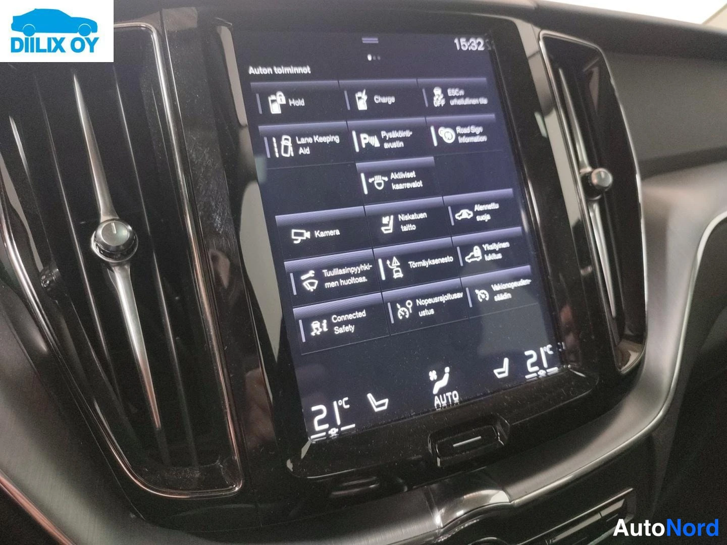 Sivulta: Auton keskikonsolin pystysuuntainen infotainment-näyttö: auki oleva Auton toiminnot -valikko (mm. Lane Keeping Aid, kamera, törmäyksenesto, Connected Safety) ja