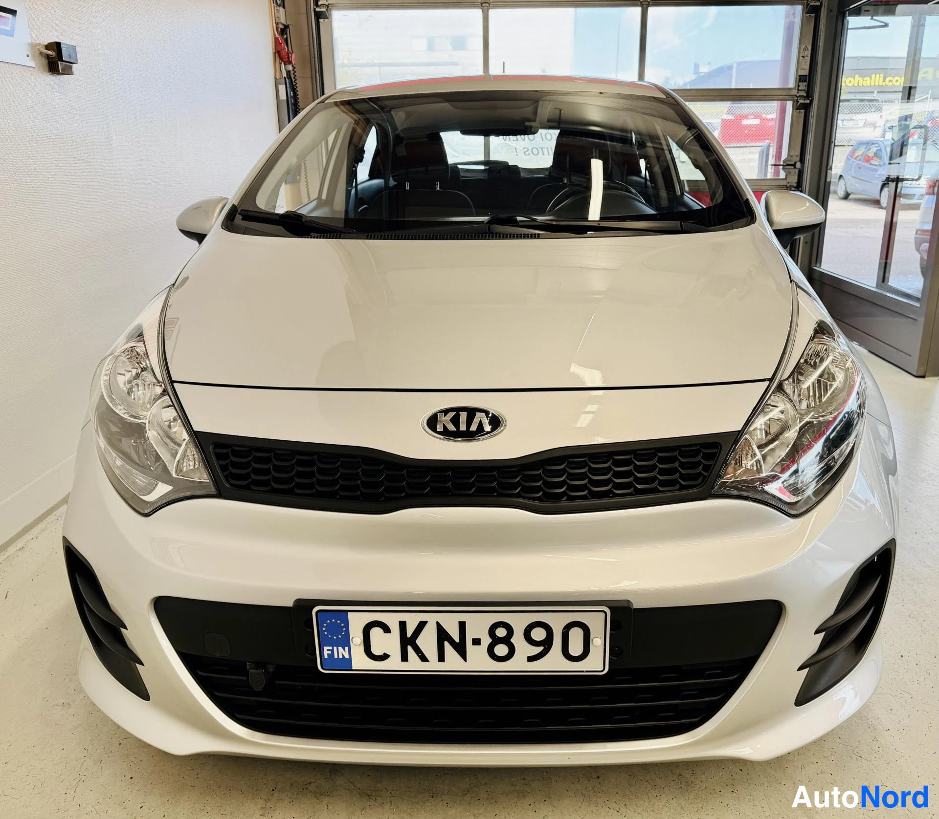 Edestä: Kia Rio suoraan edestä kuvattuna, Kia-merkki säleikkössä, rekisteritunnus