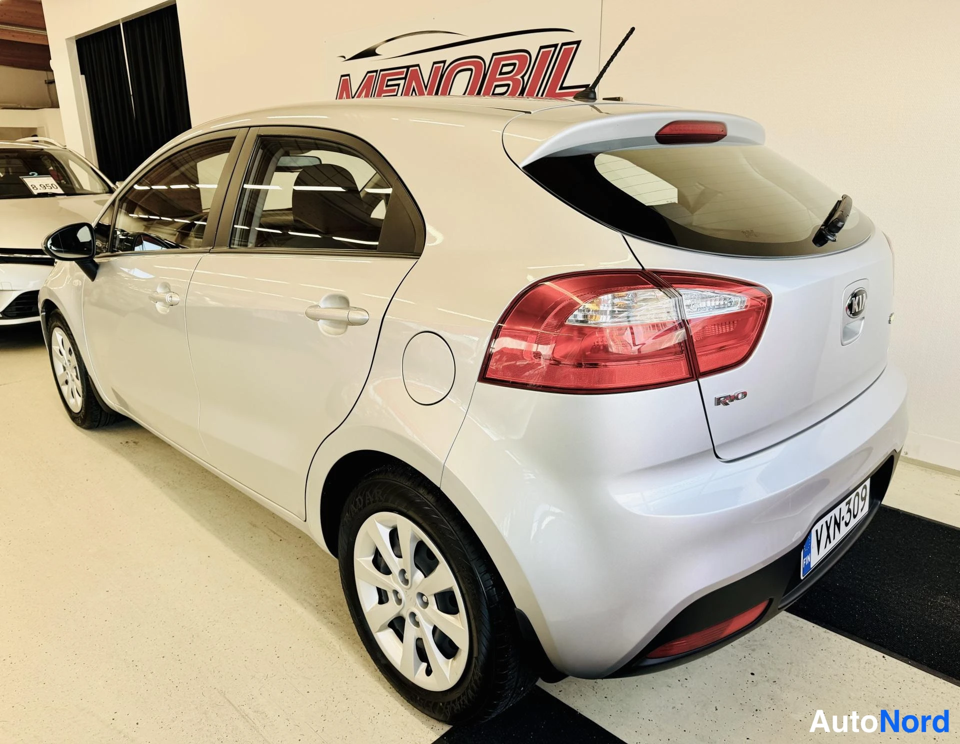 Takaviisto: Kia Rio -hatchbackin takaosa oikealta: takavalot, BOOT-luukku ja rekisterikilpi näkyvät, auto hopeanharmaana.
