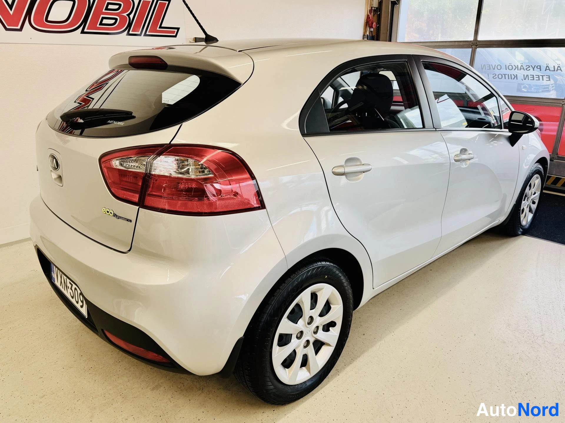 Takaviisto: Kia Rio -viistotakakulma: valkoisen farmariksen... hatchbackin takapää ja oikea kylki, rekisteri
