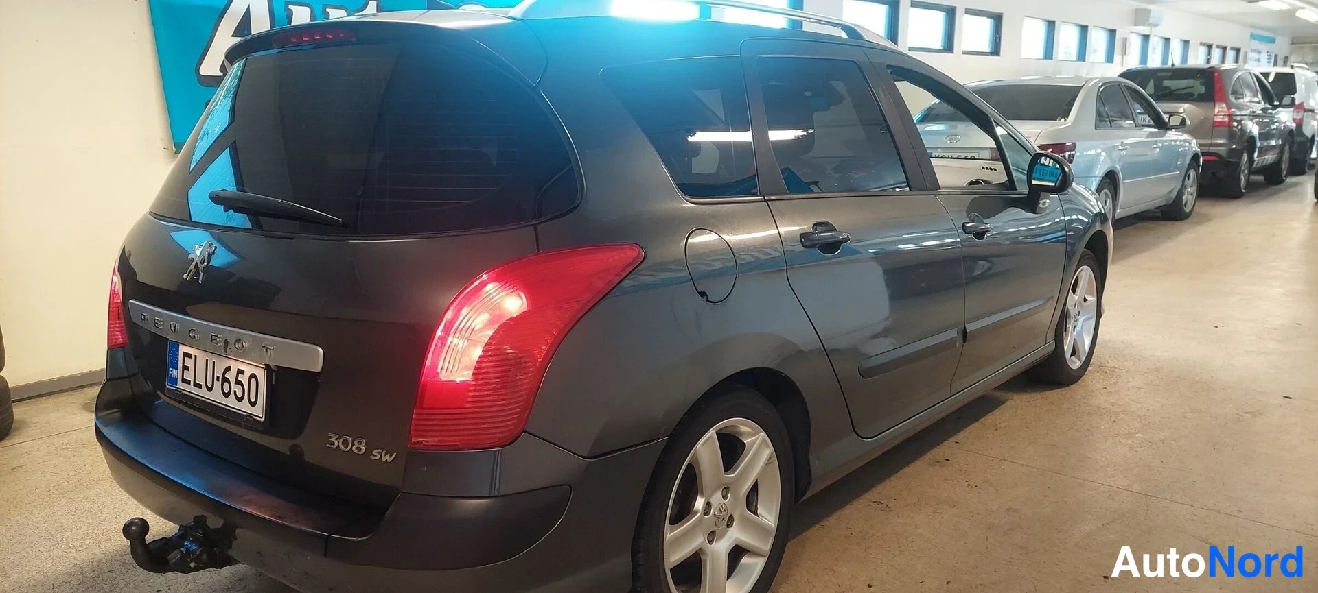 Takaviisto: Peugeot 308 SW farmari näkyy perästä ja oikealta sivulta, rekisterikilpi, 308 SW -merkintä takaluukussa, vetokoulukoukku takapuskassa
