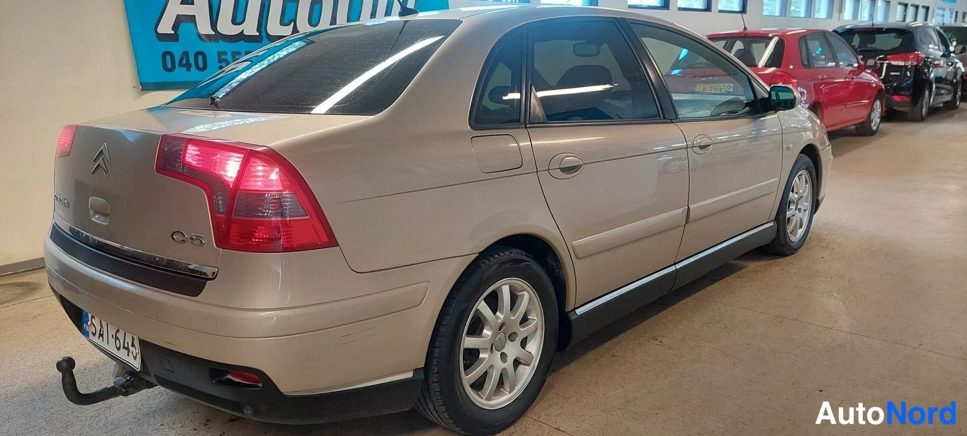 Takaviisto: Kultaiseen sävyyn maalattu Citroen C5 -sedan takaosa ja vasen kylki kuvattuna takaa vasemmalta.