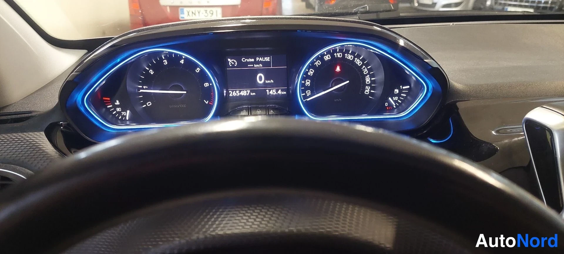 Muu: Kojelaudan mittaristo: nopeusmittari, kierroslukumittari ja näyttö, jonka lukema on 265487 km; rattia edestä.