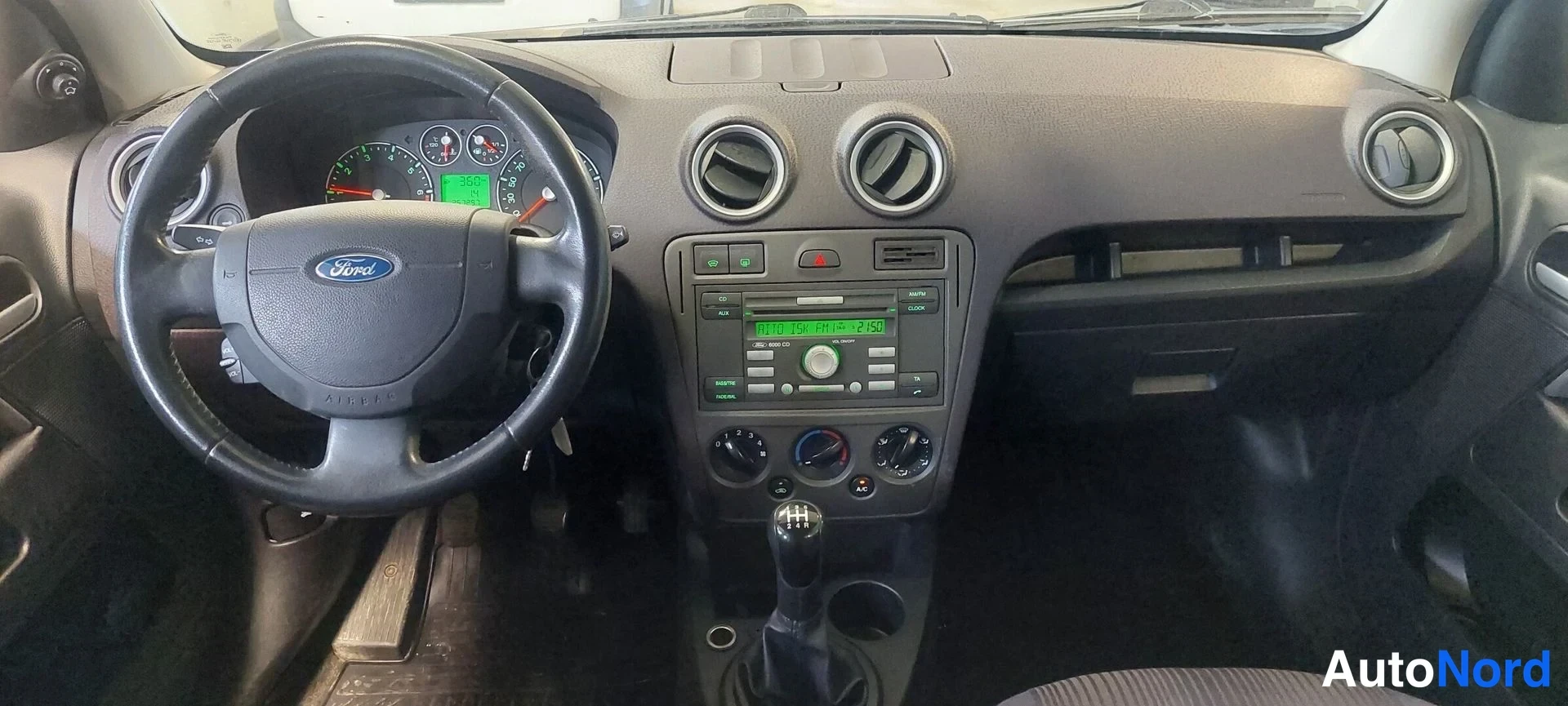 Muu: Ford-logoinen ratto, analogiset mittarit, keskikonsolissa radio- ja Audio/Clock-yksikkö, manuaalivaihteisto ja kolme pyöreää säätöpainiketta.