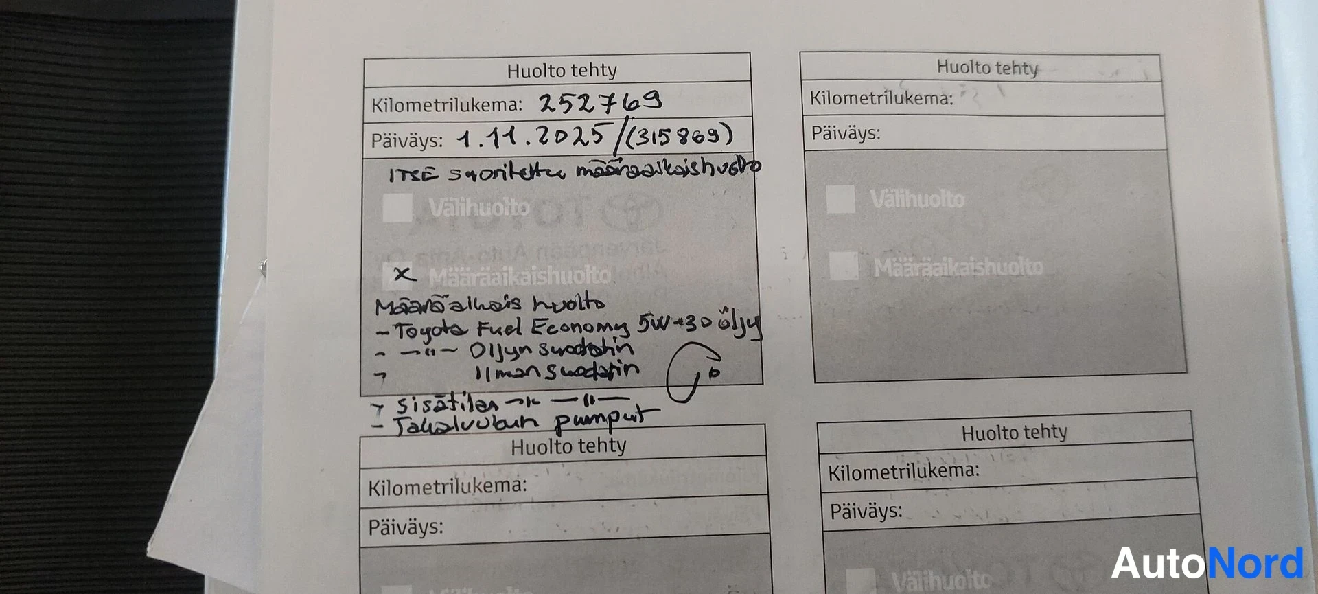 Muu: Huoltokirjan sivu, jossa käsin kirjoitettu huoltomerkintä: kilometrilukema 252 763, päiväys 1.11.2025, X-merkillä merkitty määräaikaishuolto ja käsin kirjoitett