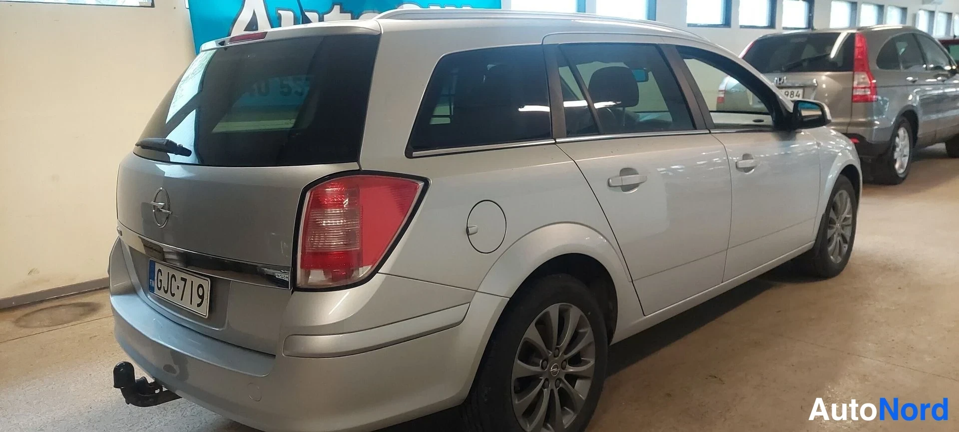 Takaviisto: Opel Astra farmarin takaosa ja oikea sivu takaviistosta, rekisteritunnus.