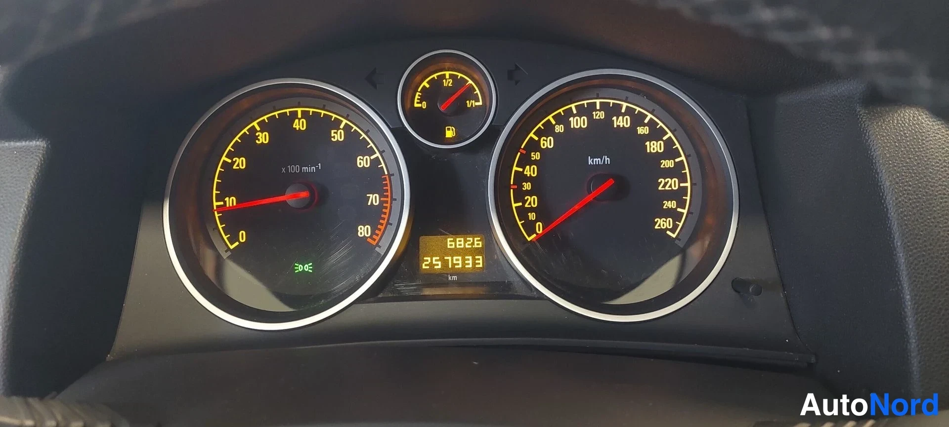Muu: Mittariston lähikuva: nopeusmittari, kierrosmittari, polttoainemittari ja matkamittari 257933 km.