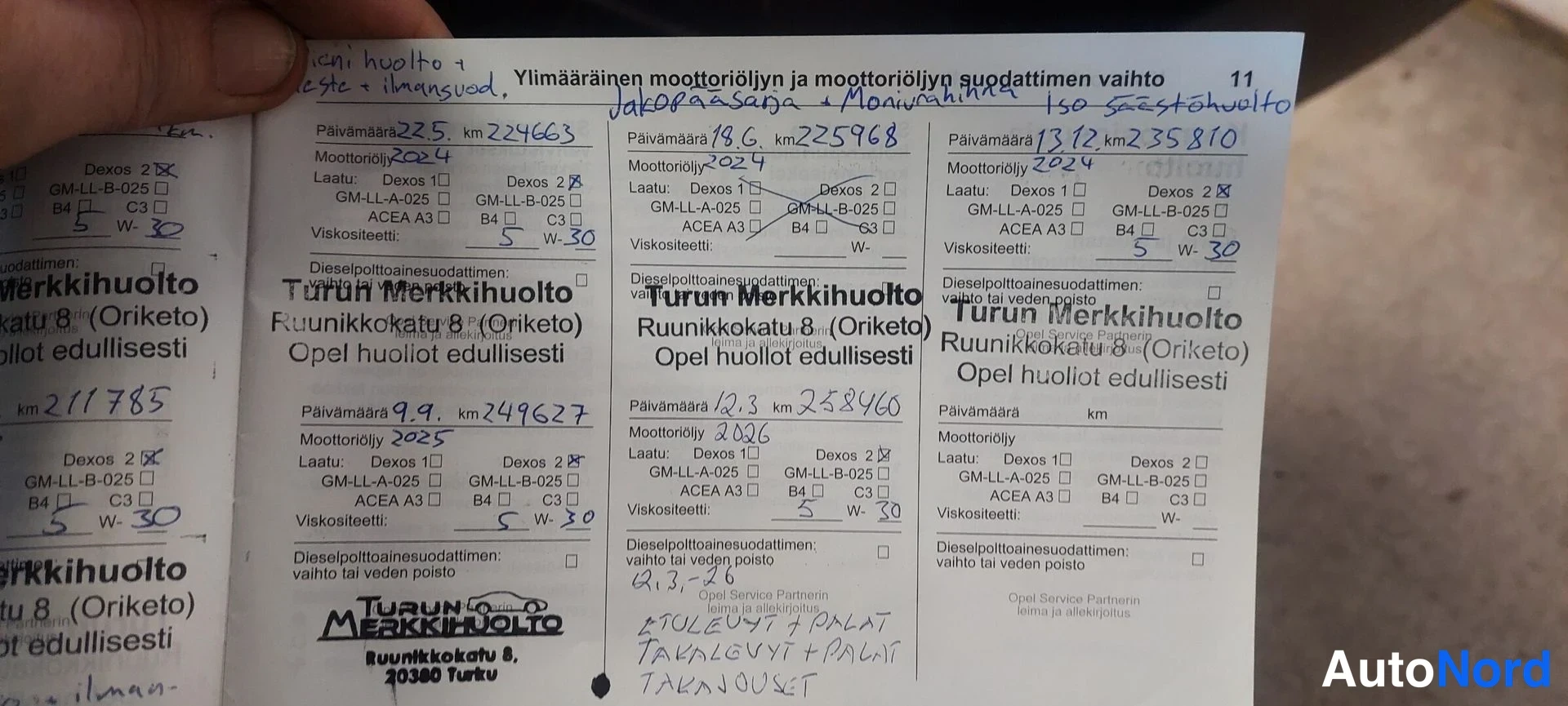 Yksityiskohta: Auki pidetty huoltokirja, jossa käsin kirjattuja ylläpitomerkintöjä: ylimääräinen moottoriöljyn ja suodattimen vaihto, Turun Merkkihuolto.