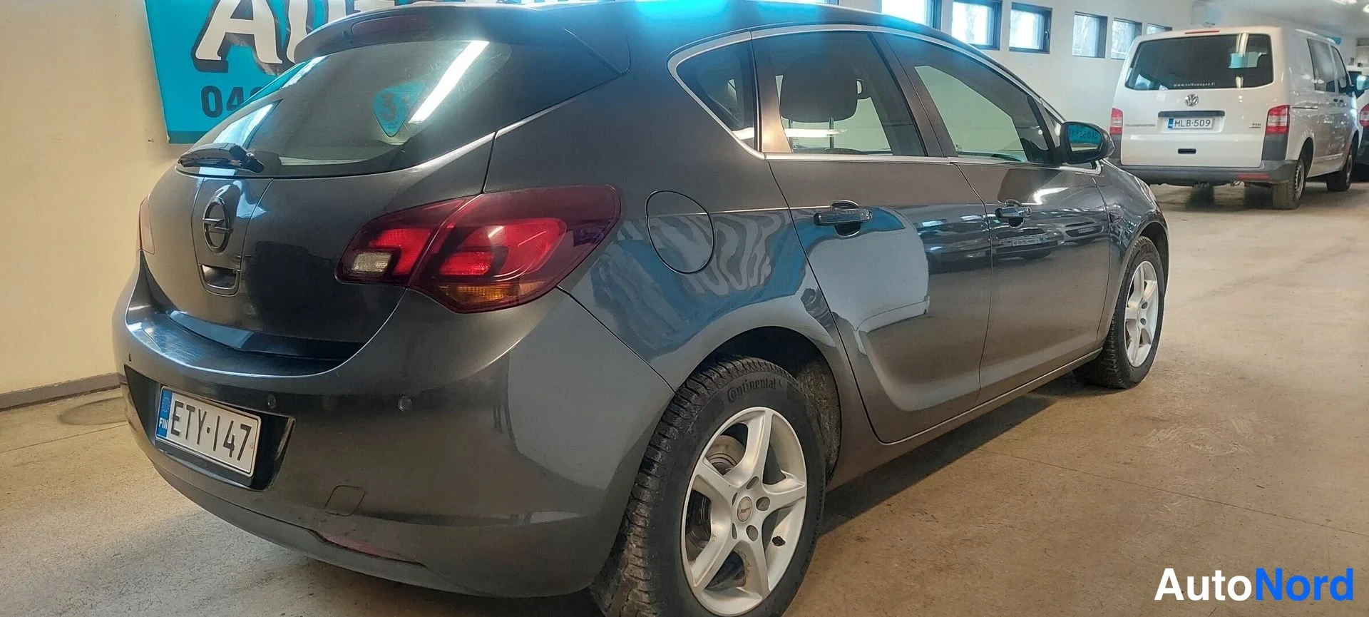 Takaviisto: Harmaa Opel Astra -henkilöauto kolmannelta sektorilta takaa vasemmalta sisätiloissa.