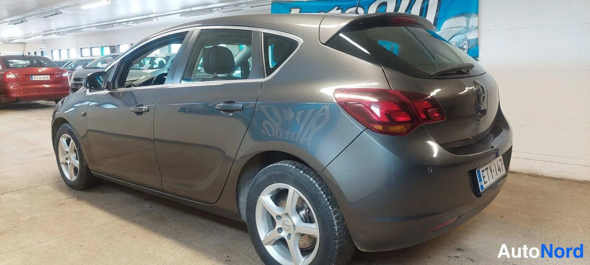 Takaviisto: Harmaa Opel Astra -henkilöauto kolmannelta sektorilta takaa vasemmalta sisätiloissa.