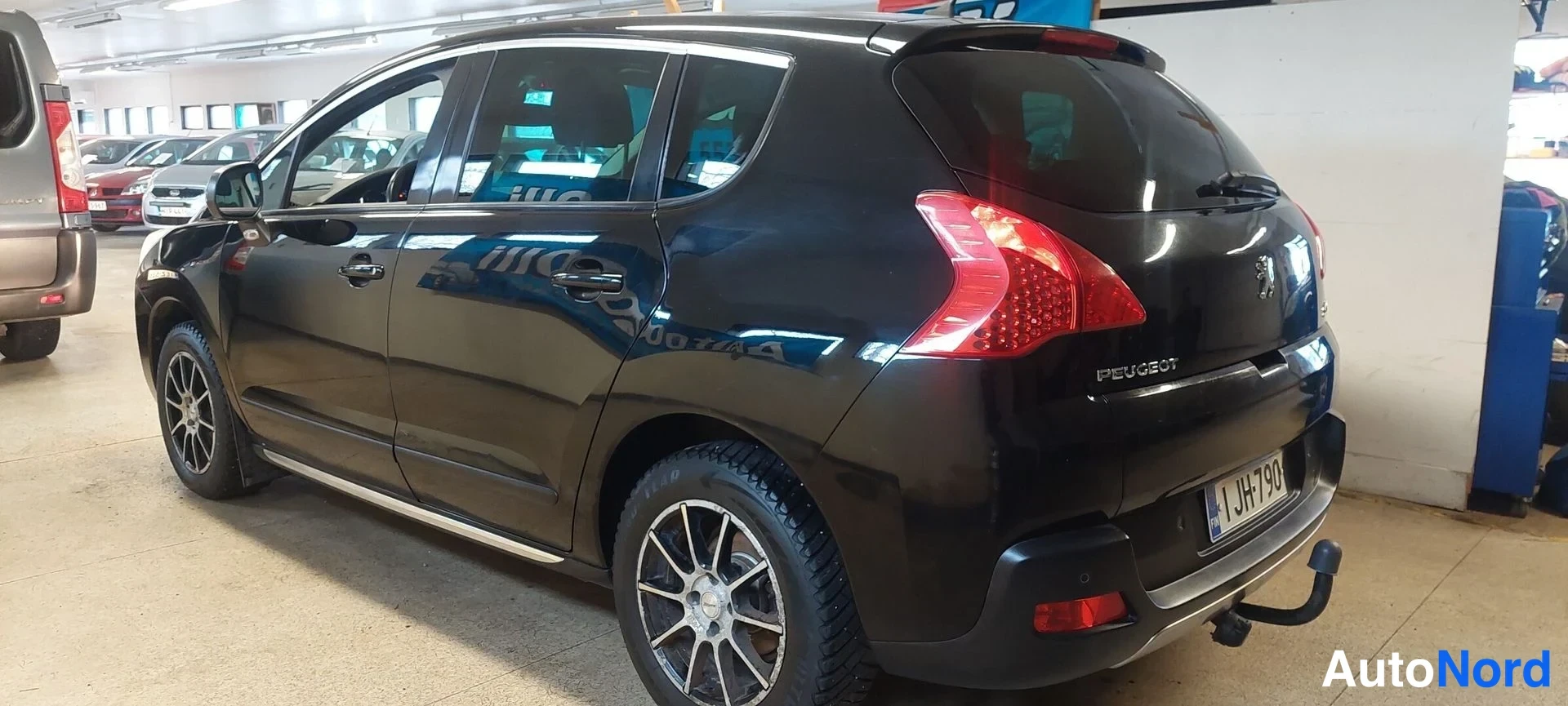 Takaviisto: Mustan Peugeot 3008:n takakulma oikealta, rekisterikilpi ja vaunukoulu.
