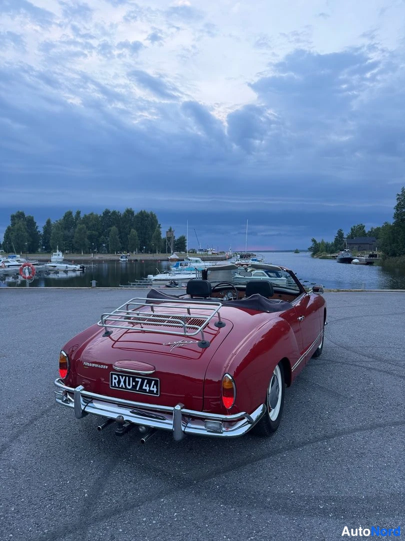 Takaviisto: Punainen avokauto takaa viistosti kuvattuna satamassa, rekisteritunnus, takaluukulla tavarateline.