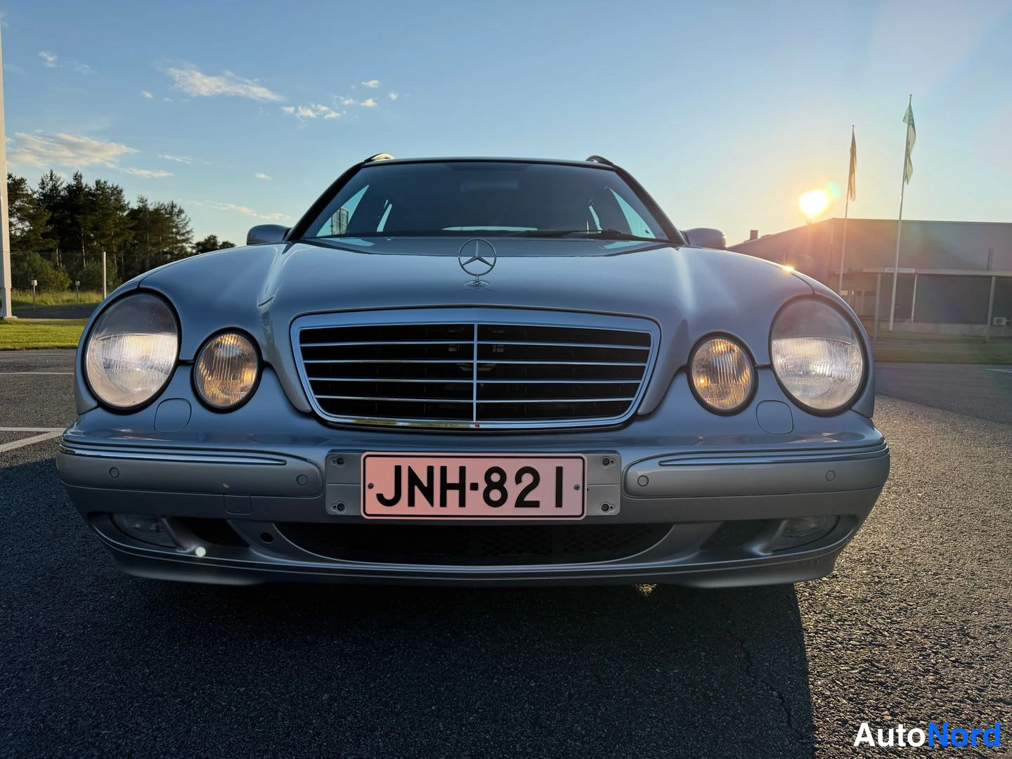 Edestä: Farmarimerkki hopeanvärinen Mercedes-Benz suoraan edestä, rekisteritunnus.