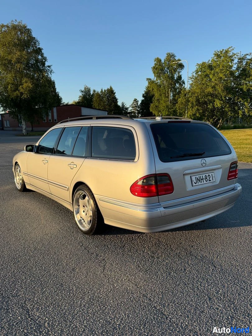 Takaviisto: Hopeanvärinen farmariauto takaa viistosta, rekisterikilpi.