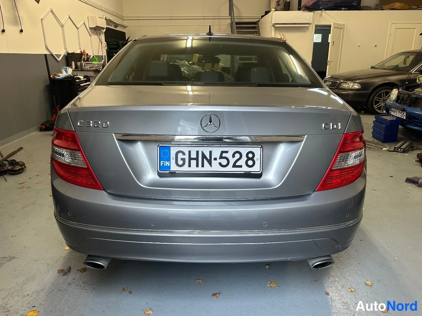 Takaa: Mercedes-Benz C 320 -sedanin takaosa näkyy suoraan takaa rekisteritunnus, hopeanharmaa kori ja kaksi pakoputkea.