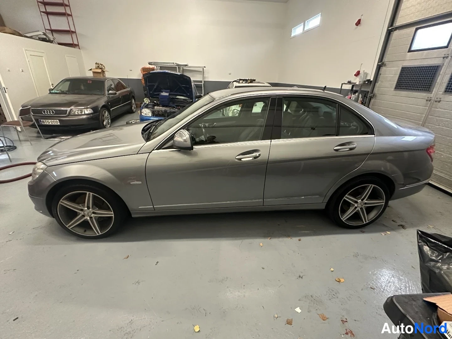 Sivulta: Mercedes-Benz C 320 -sedan sivuprofiili vasemmalta talossa, hopeanharmaa kori ja viisipuolaiset kevytmetallivanteet.
