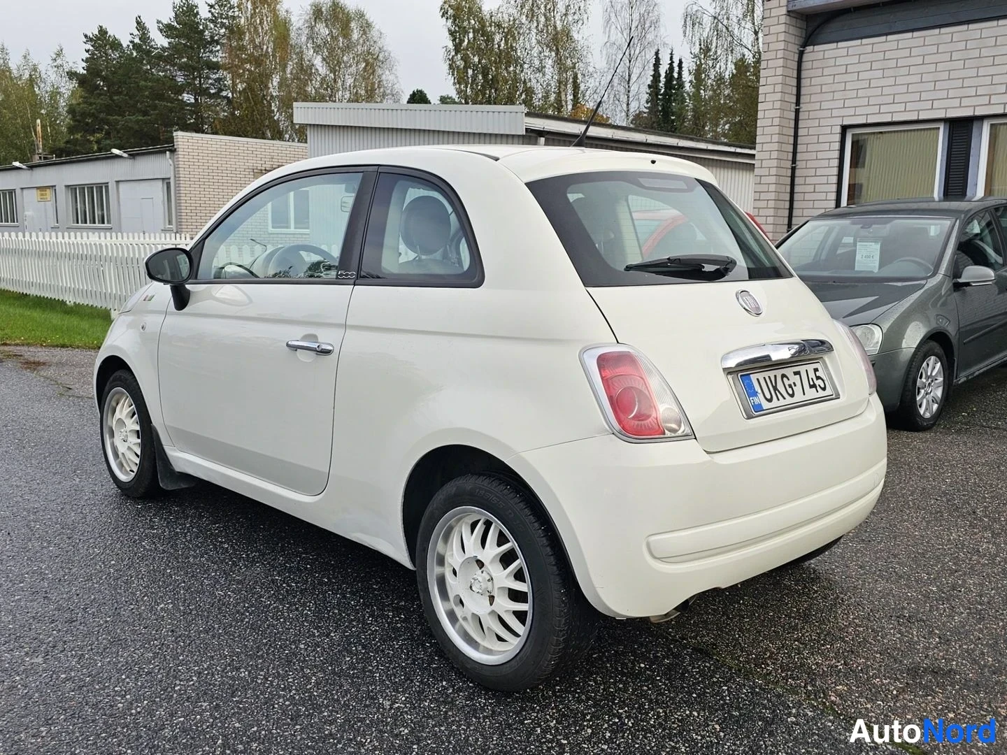 Takaviisto: Valkoinen Fiat 500 takaosakulmasta, takavalot ja rekisteritunnus näkyvissä.