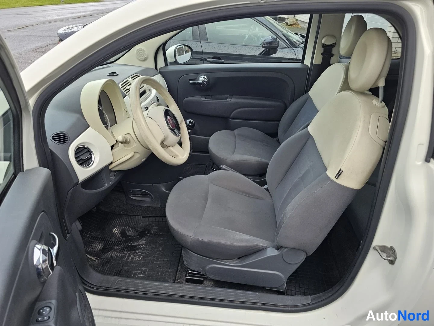 Sivulta: Fiat 500:n matkustamisto vasemmalta oven kautta, harmaat istuimet ja beigea sisustaa