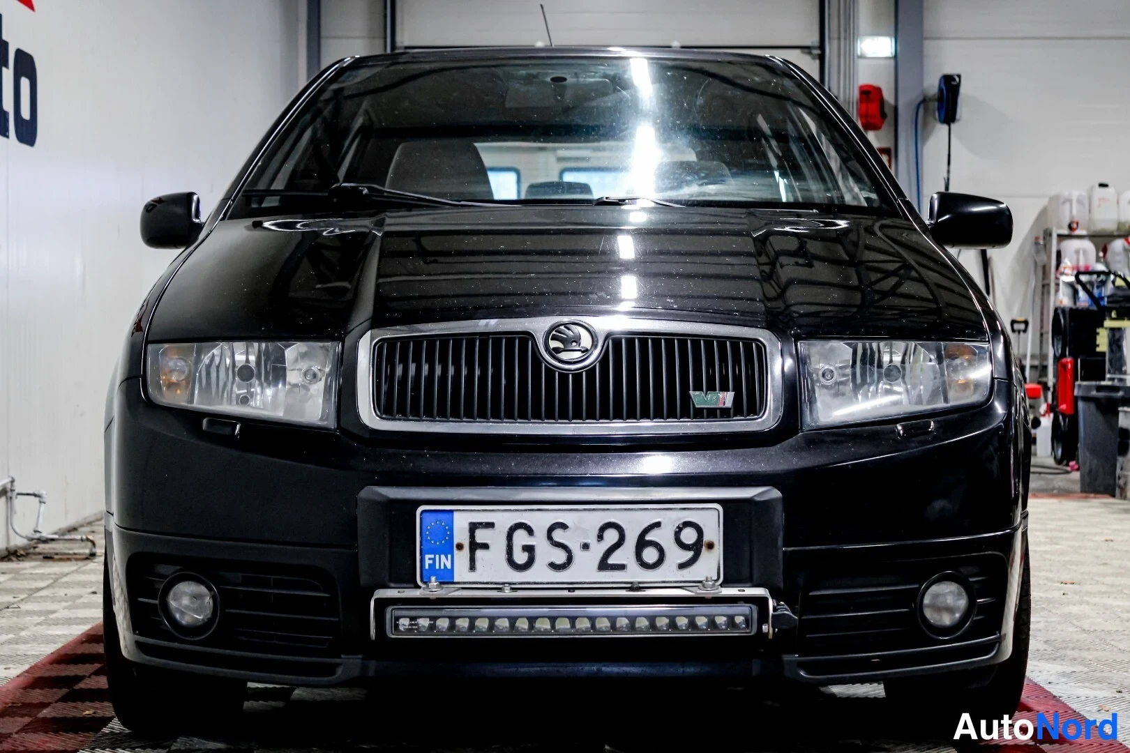 Edestä: Mustan henkilöauton keula suoraan edestä:, sumuvilkut ja LED-tanko puskurissa.