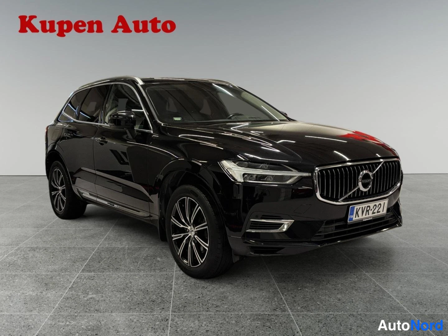 Etuviisto, nokka oikealle: Mustan Volvo XC60:n etukulma oikealta kuvattuna, jäähdelähdin ja rekisterikilpi näkyvät