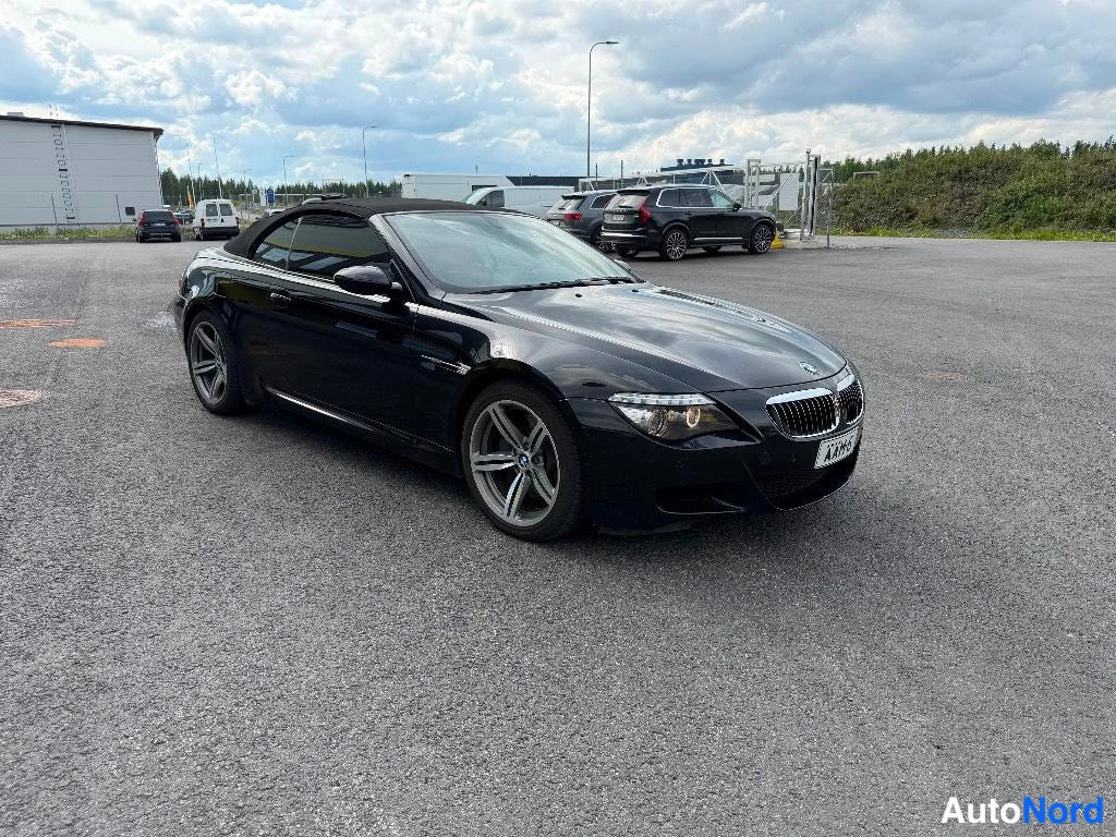 Etuviisto, nokka oikealle: Musta avoauto BMW katukuvassa, etukulma oikealta